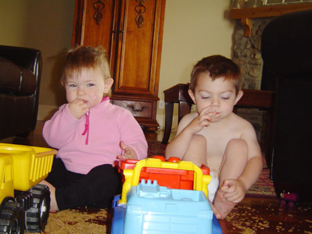 Grace and Micah with trucks and cereal mess